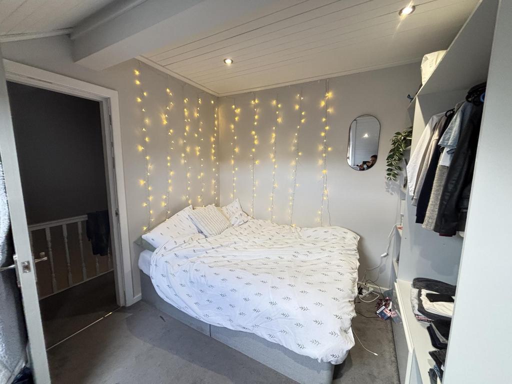 A bright and welcoming bedroom featuring a neat...