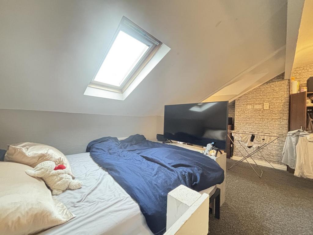 A cozy bedroom featuring a bed with a dark blue...