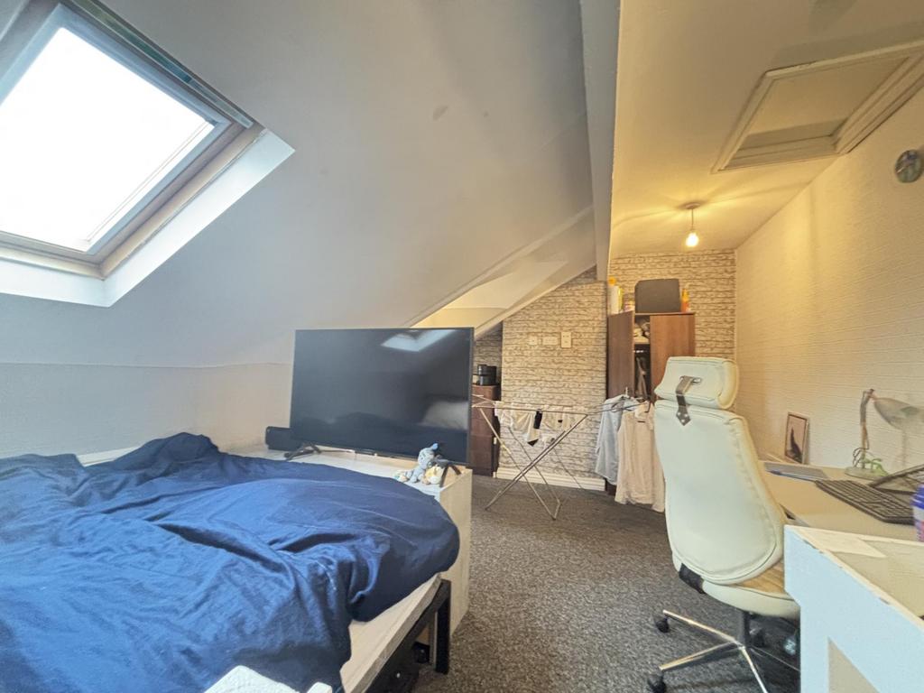 A well-lit bedroom featuring a comfortable bed,...
