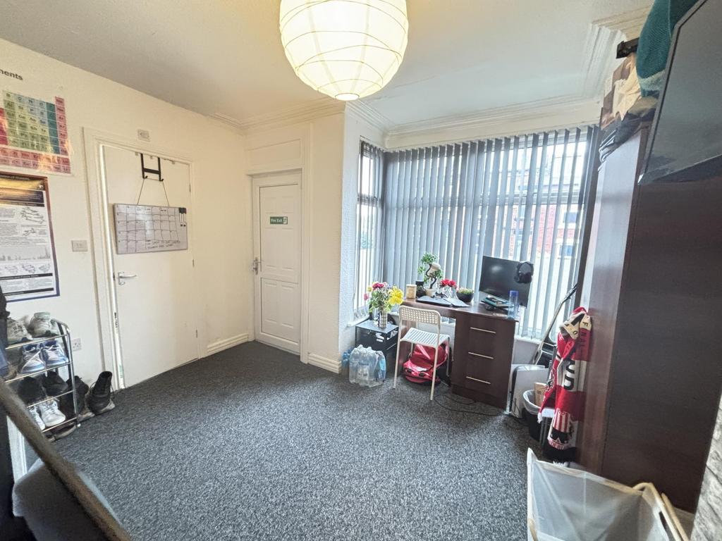 A tidy and well-lit room with a window allowing...