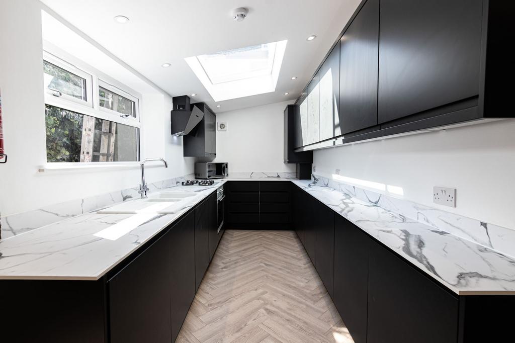 Modern and sleek kitchen featuring black cabine...