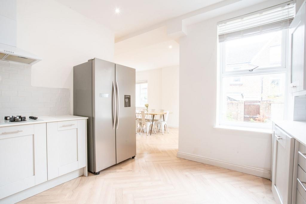 Bright and modern kitchen with white cabinetry,...