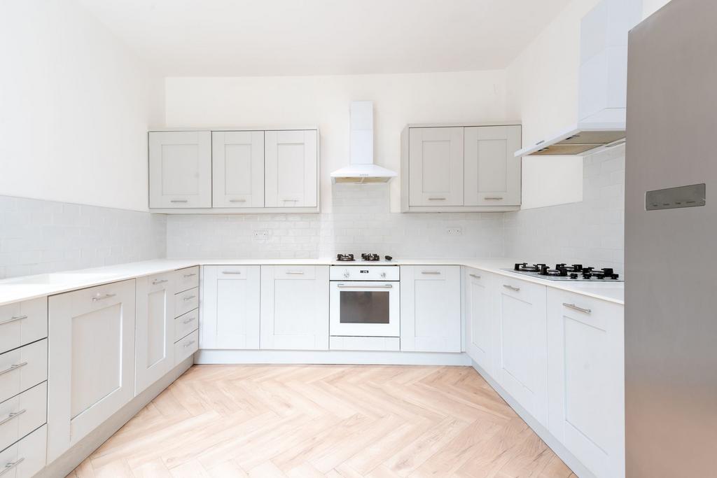 Bright and modern kitchen with extensive white ...