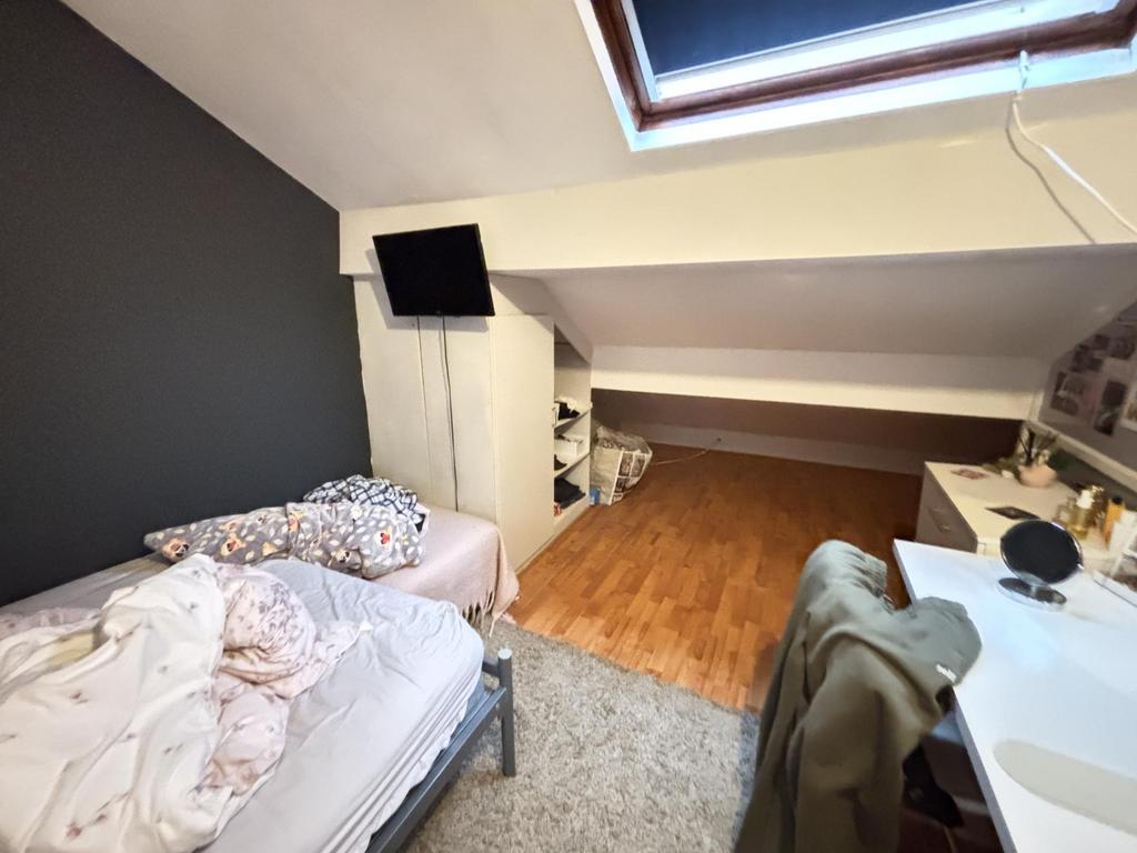 A cozy bedroom with a comfortable bed, a desk, ...