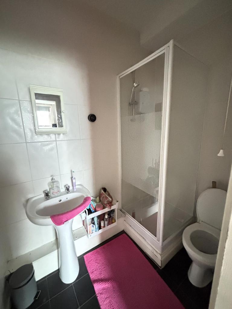 Bright and clean bathroom with a shower enclosu...