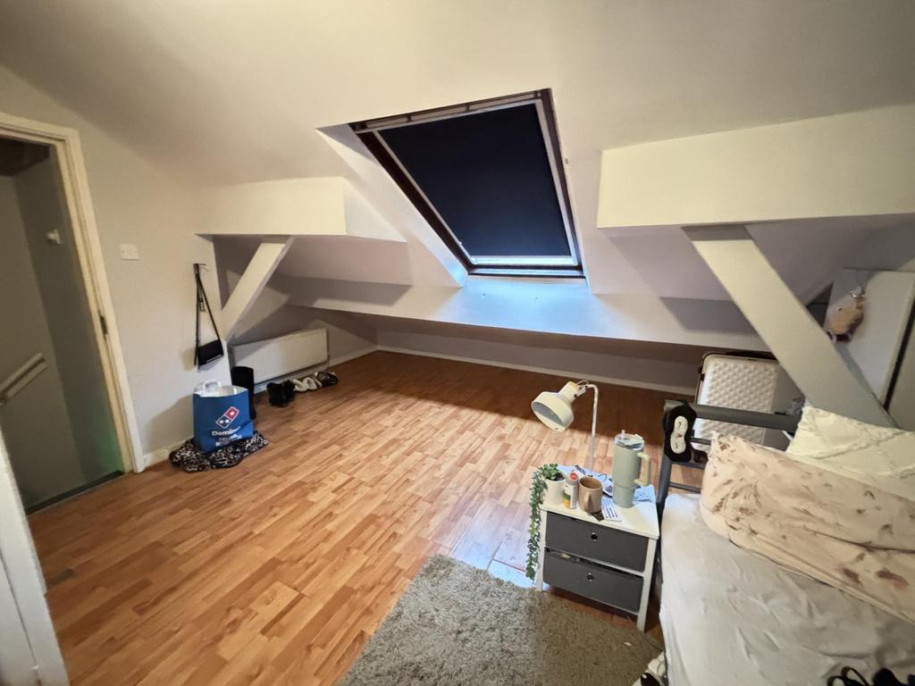 A cozy attic room with a sloped ceiling featuri...