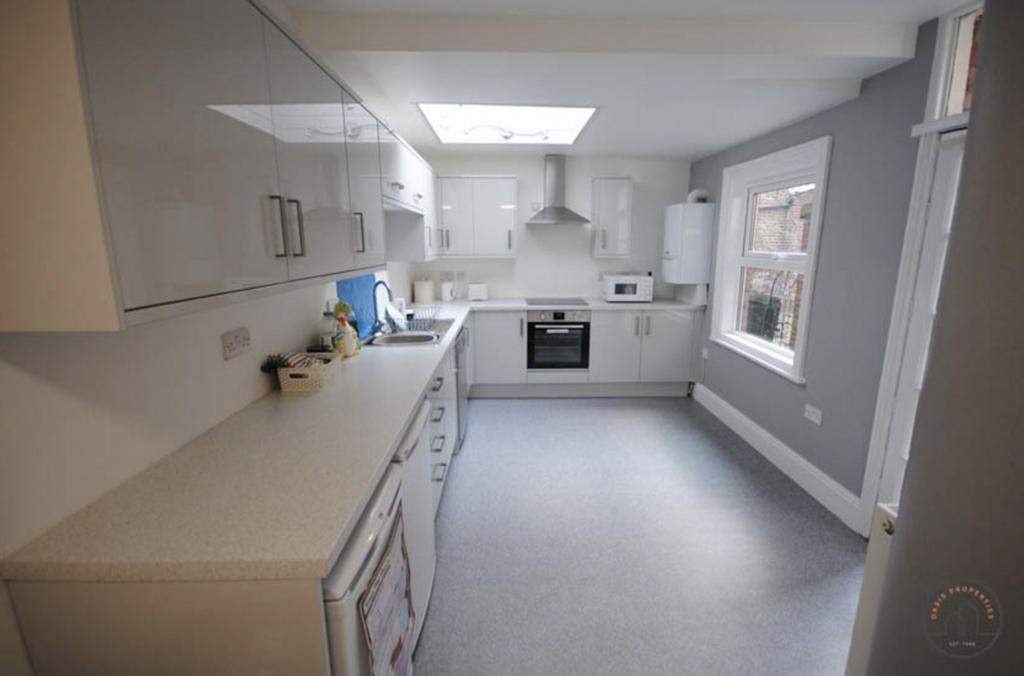 Bright and clean kitchen area featuring white c...