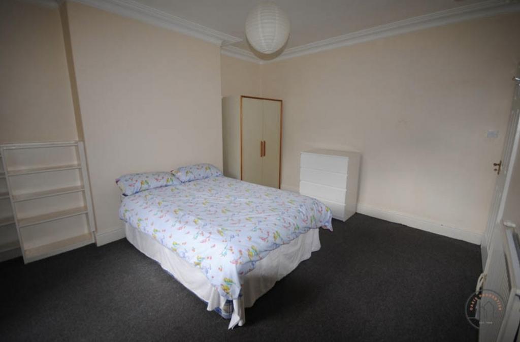 A spacious double bedroom featuring a comfortab...