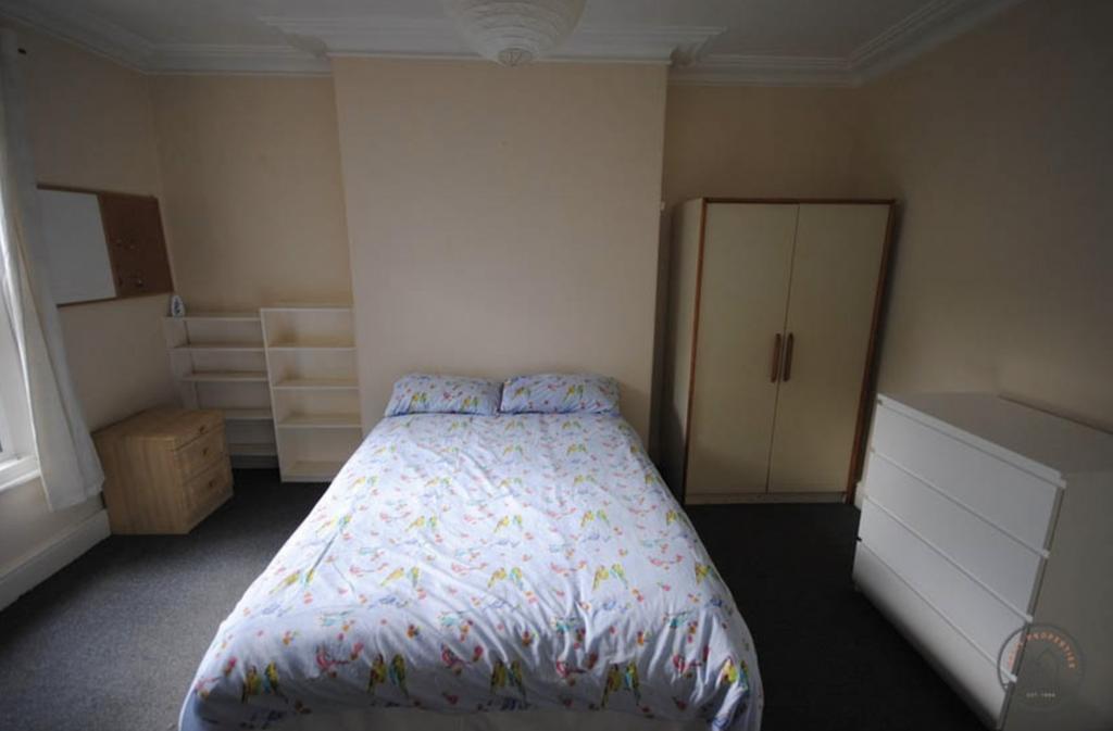 A tidy and well-lit double bedroom featuring a ...