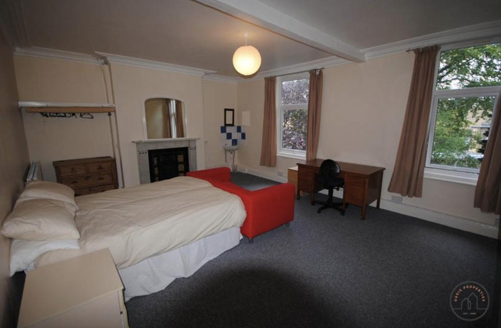 A spacious double bedroom featuring a comfortab...
