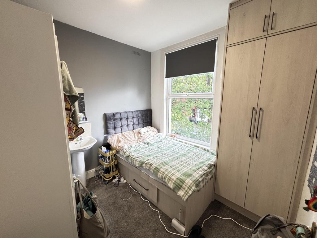 A cozy bedroom featuring a neatly made bed with...