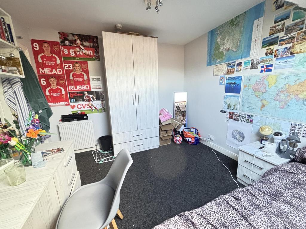 A well-organized student bedroom featuring a co...
