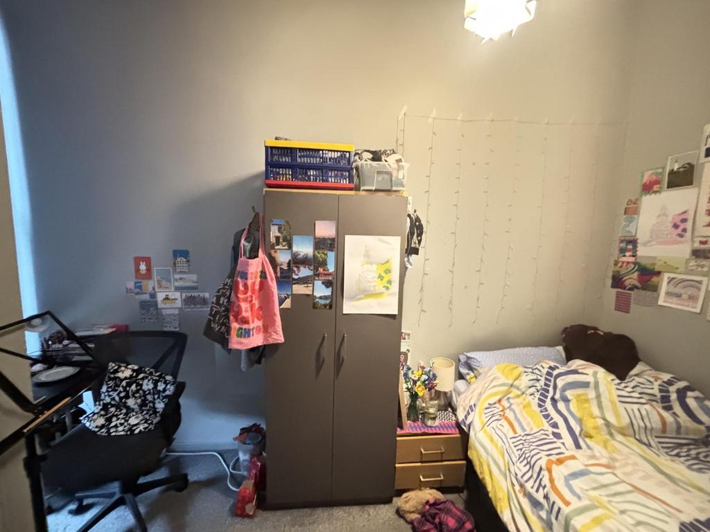 A cozy bedroom featuring a bed, wardrobe, and p...