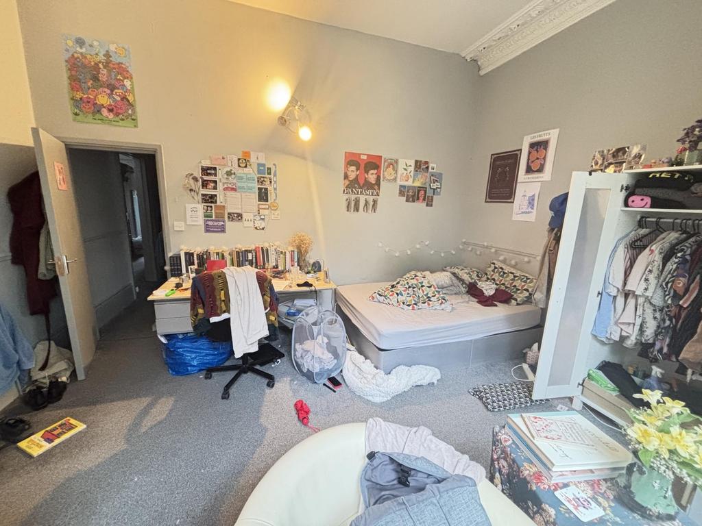 A cozy bedroom featuring a large bed and person...