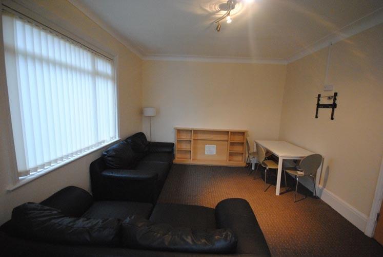A spacious, well-lit living room featuring two ...
