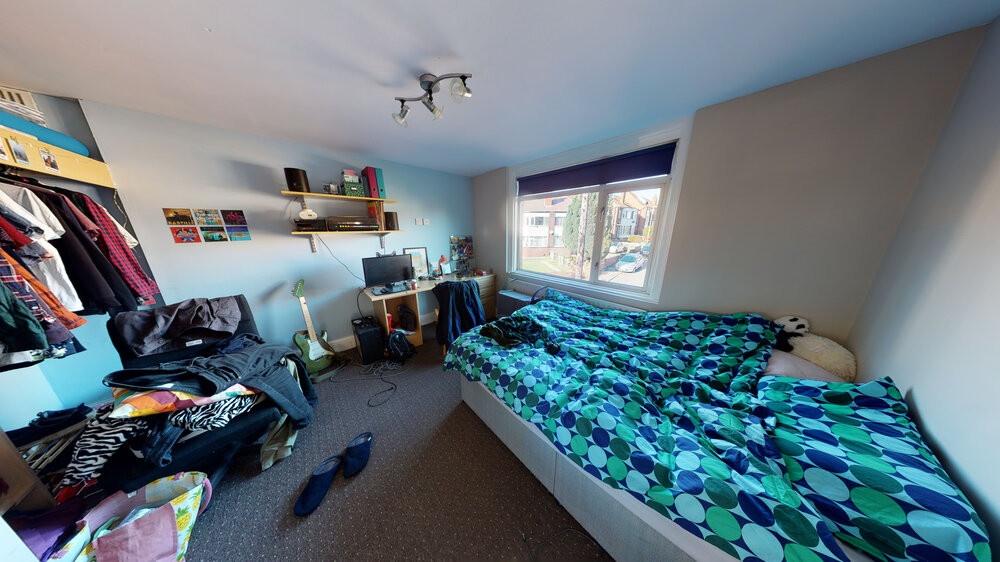 A cozy bedroom featuring a neatly made bed with...