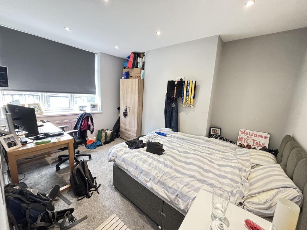 A cozy bedroom featuring a comfortable bed, a w...