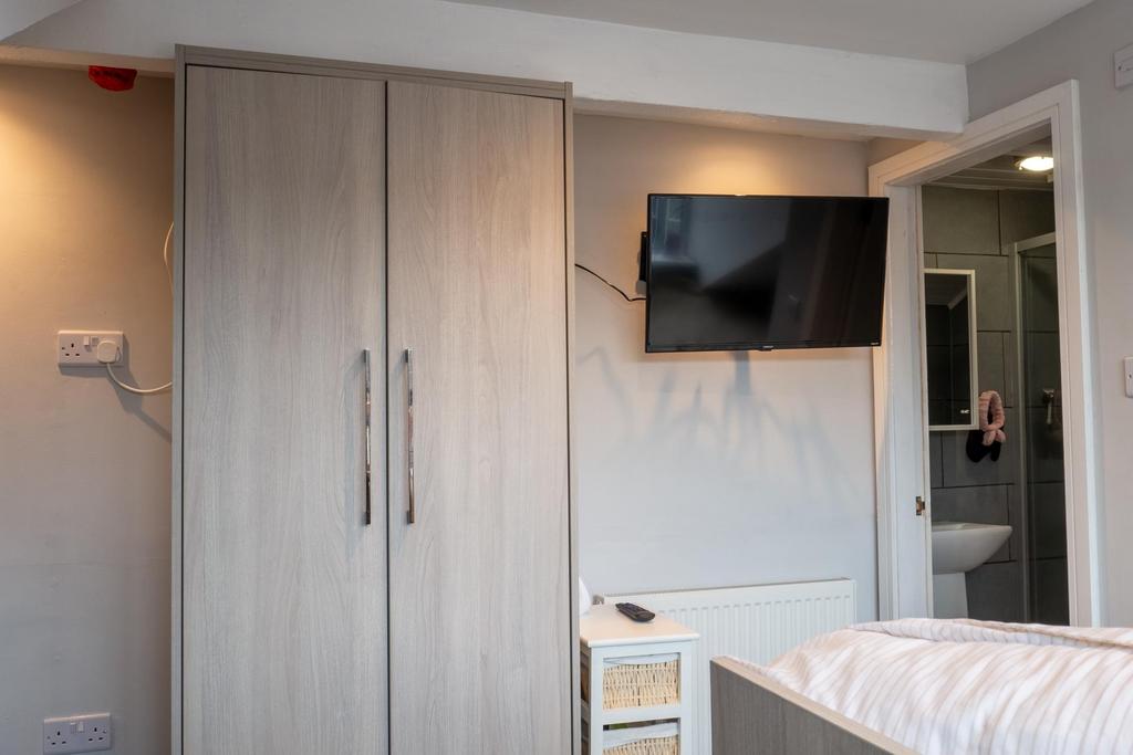 A bright and tidy bedroom featuring a wardrobe ...
