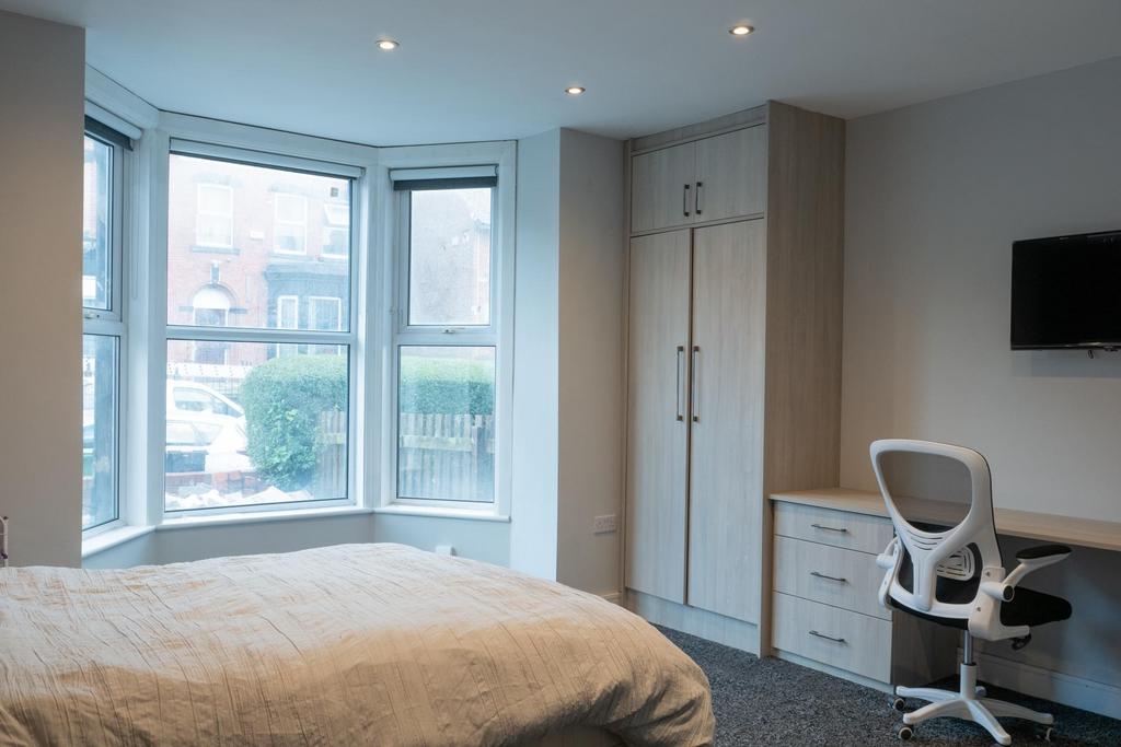 A bright and tidy bedroom featuring a comfortab...