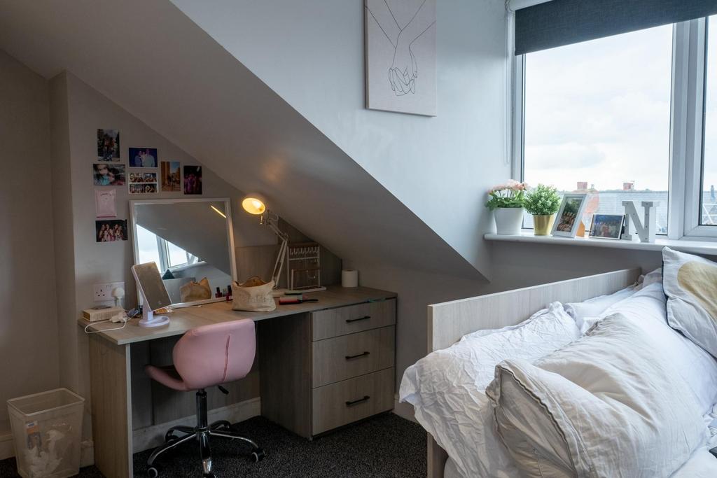 A cozy and well-lit bedroom featuring a comfort...