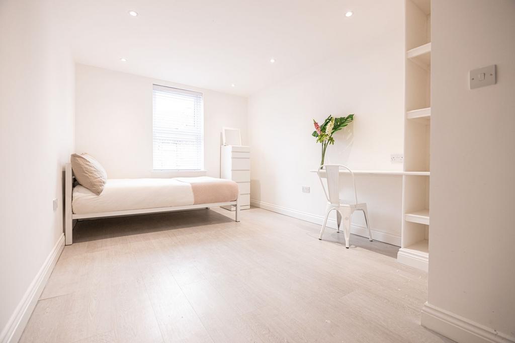 Bright, minimalist single bedroom with a comfor...