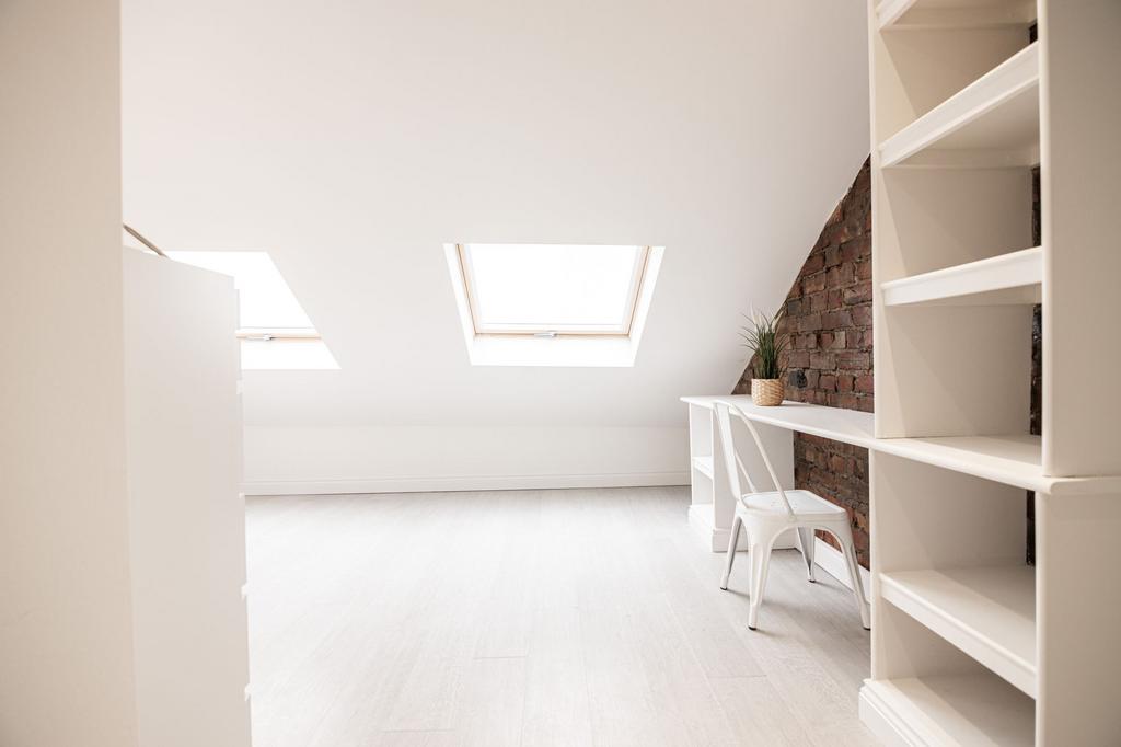 Bright, minimalist attic workspace with two sky...