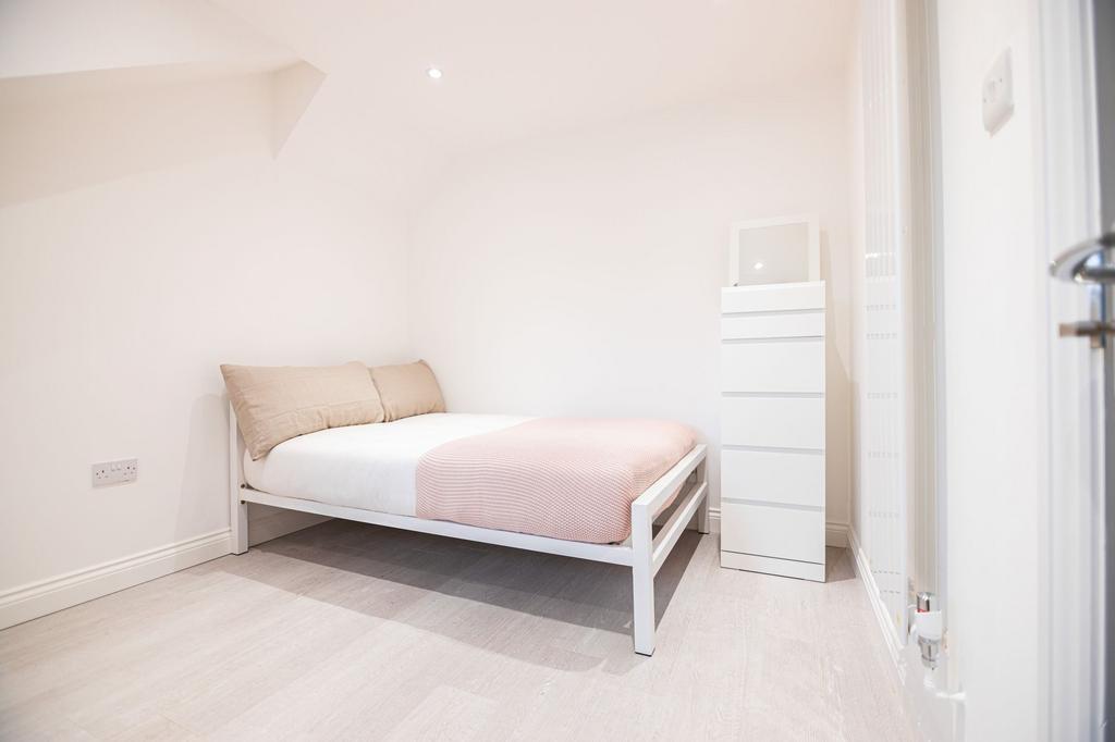 Bright, minimalist double bedroom with a white ...