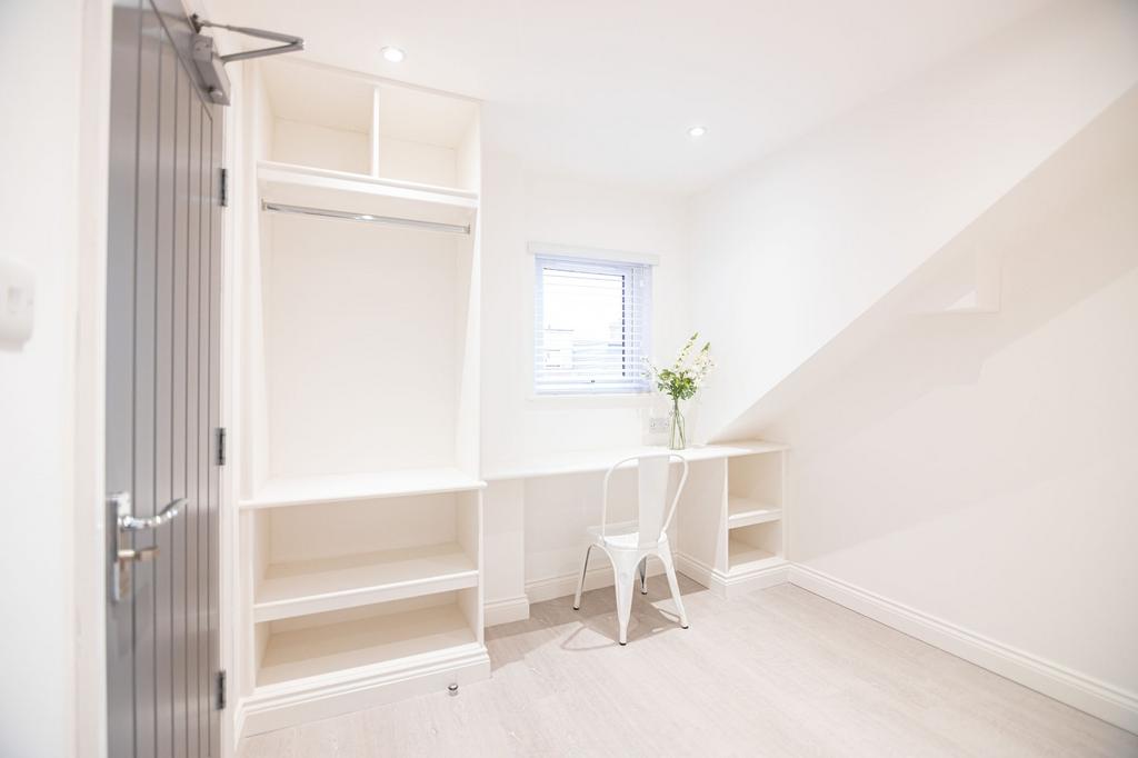 Bright, freshly decorated bedroom with built-in...