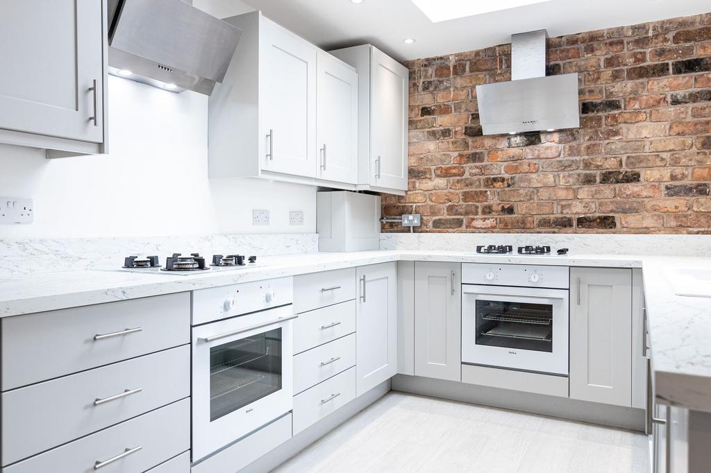 Bright, modern fitted kitchen with white marble...