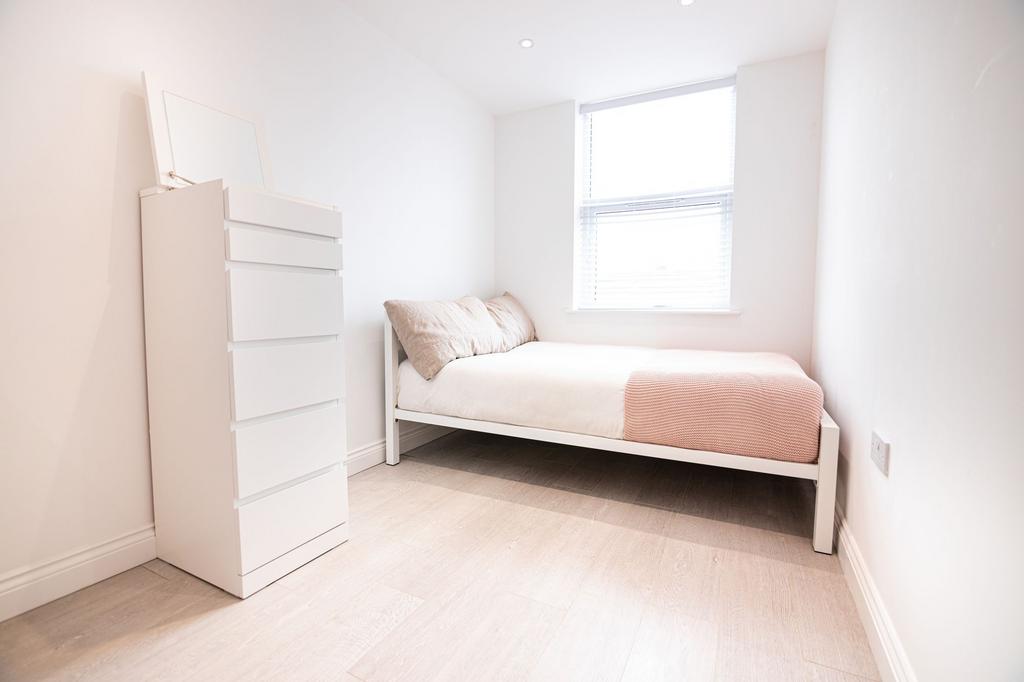 Bright, minimalist single bedroom with a comfy ...