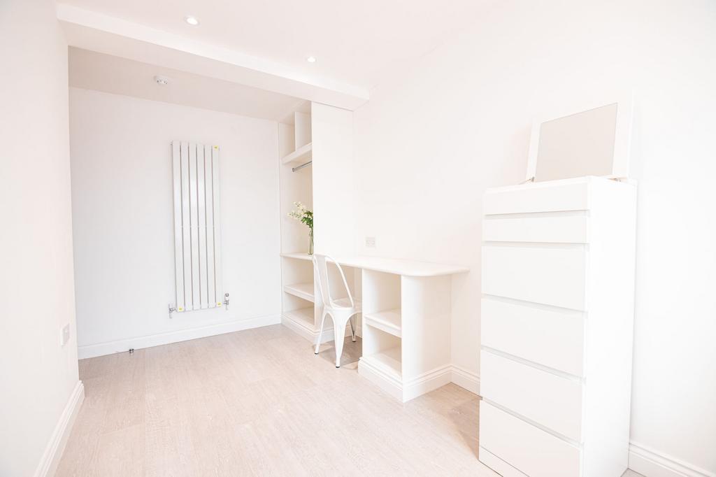 Bright, minimalist single bedroom with built-in...