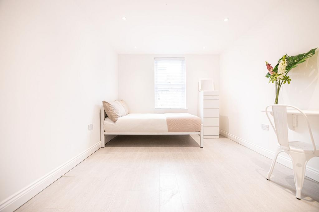 Bright, minimalist double bedroom with a comfor...