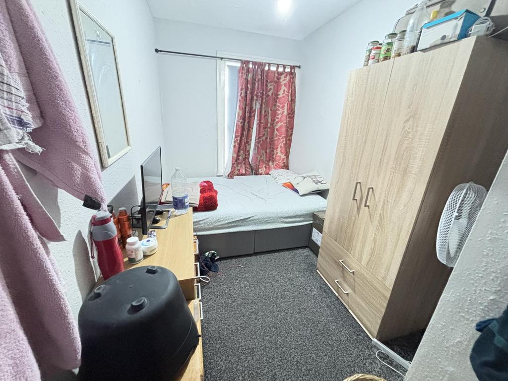 A well-lit, spacious double bedroom featuring a...