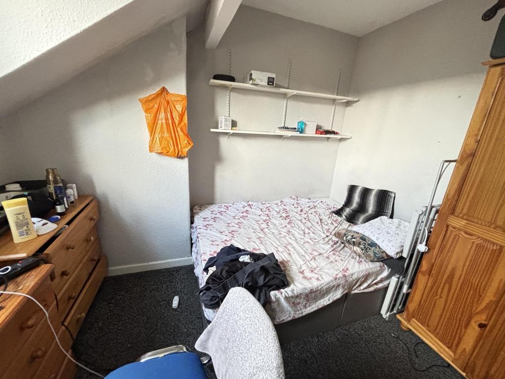 A cozy bedroom featuring a double bed with pill...