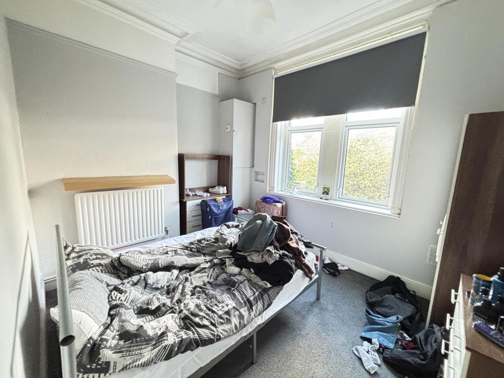 A cozy bedroom with a double bed and window pro...