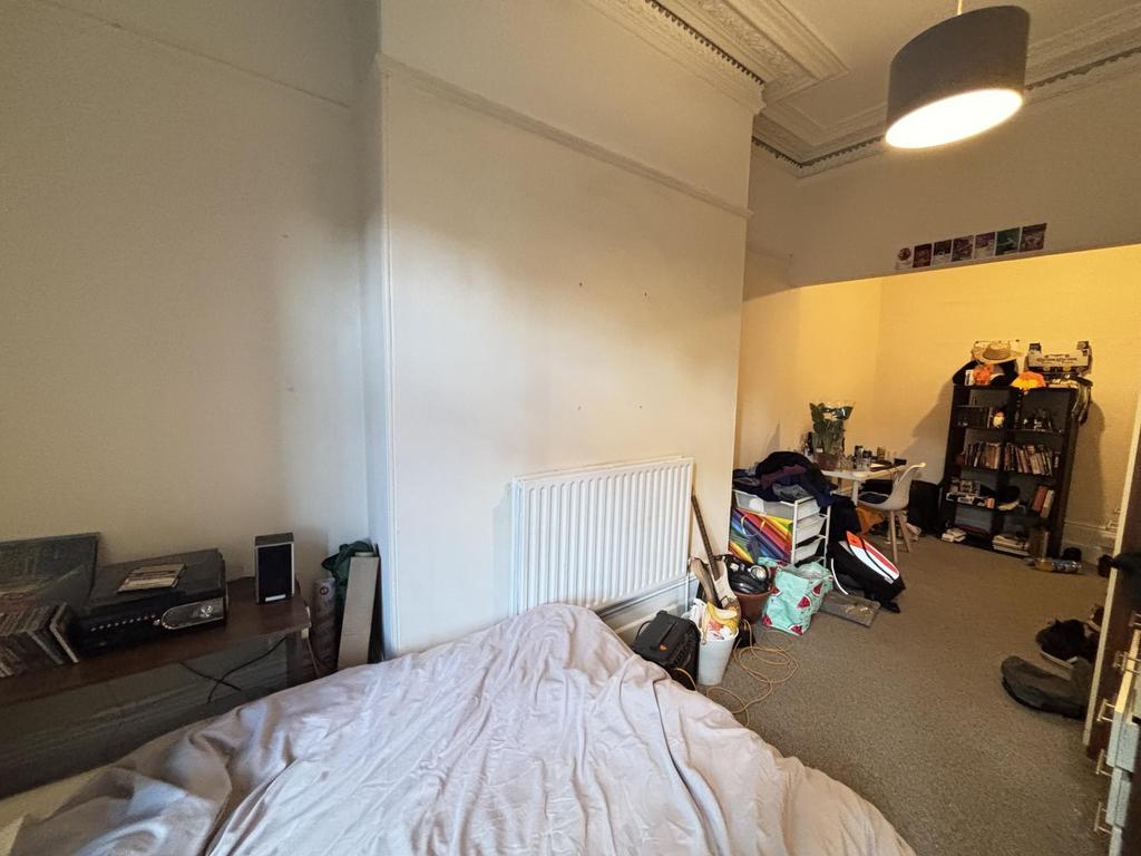 A cozy bedroom featuring a cozy bed with a head...