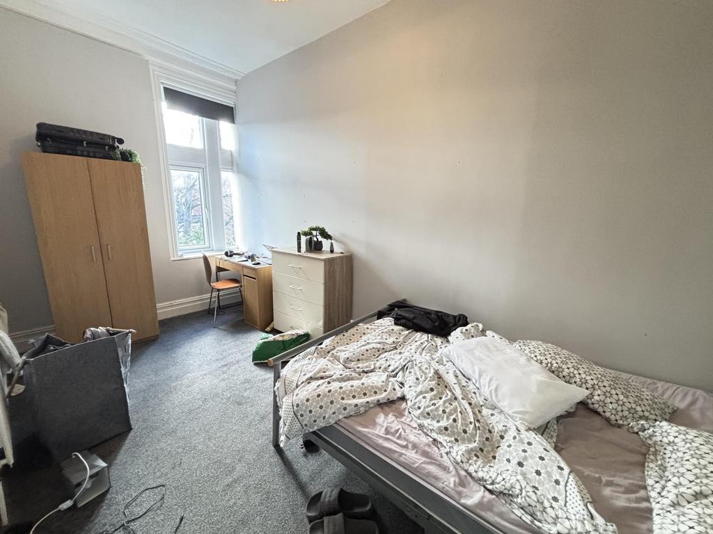 A cozy bedroom with a bed shortly made, natural...