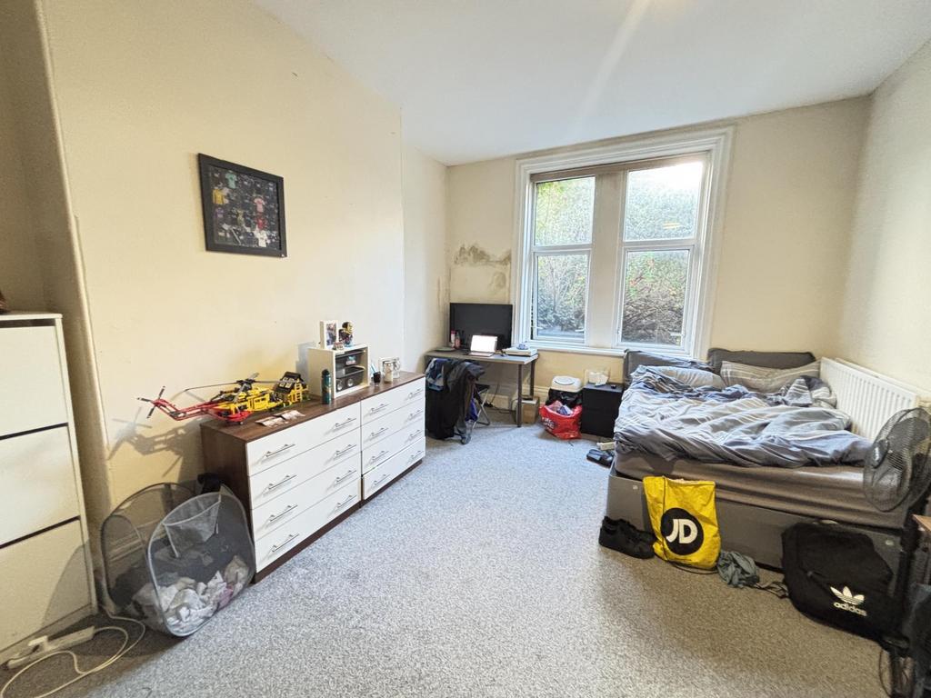 A cozy bedroom featuring a bed with some beddin...