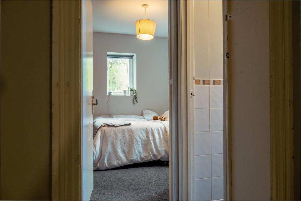 A bright and tidy bedroom featuring a comfortab...