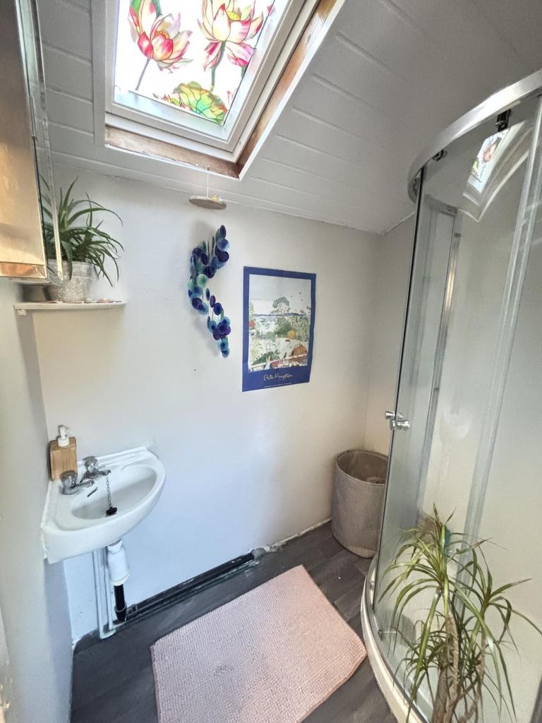 A bright and tidy bathroom with a corner shower...