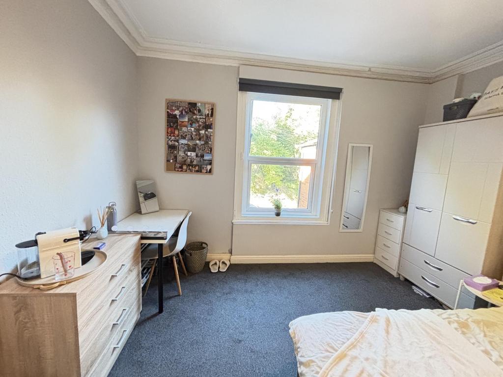 A bright and well-maintained bedroom featuring ...