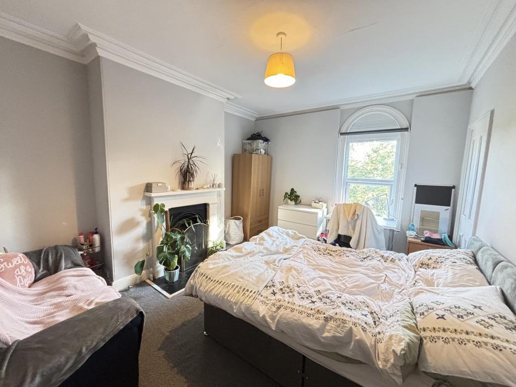 A bright and welcoming bedroom featuring a comf...