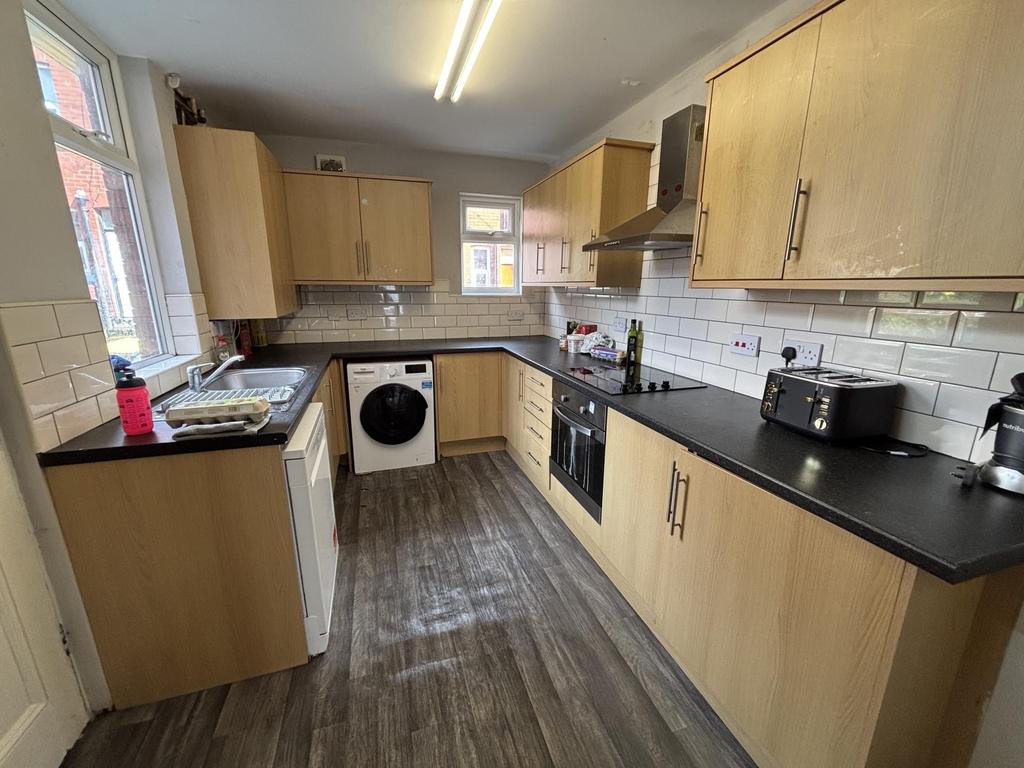 A modern kitchen with ample cabinet space, a wa...