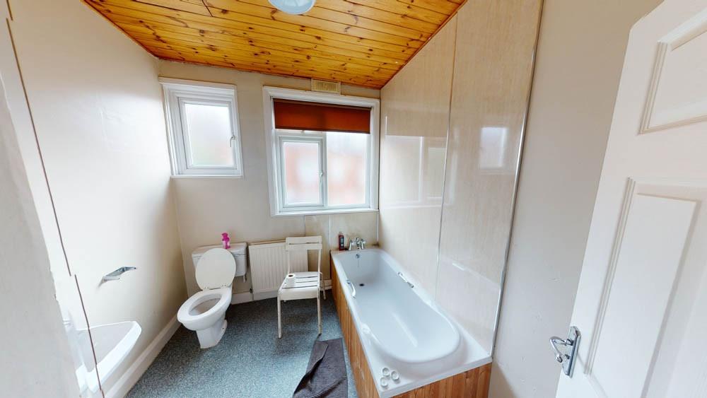 A bright and tidy bathroom featuring a bathtub,...