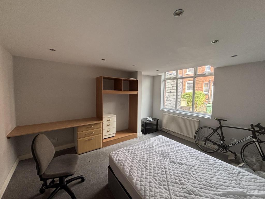 A bright and tidy student bedroom featuring a c...