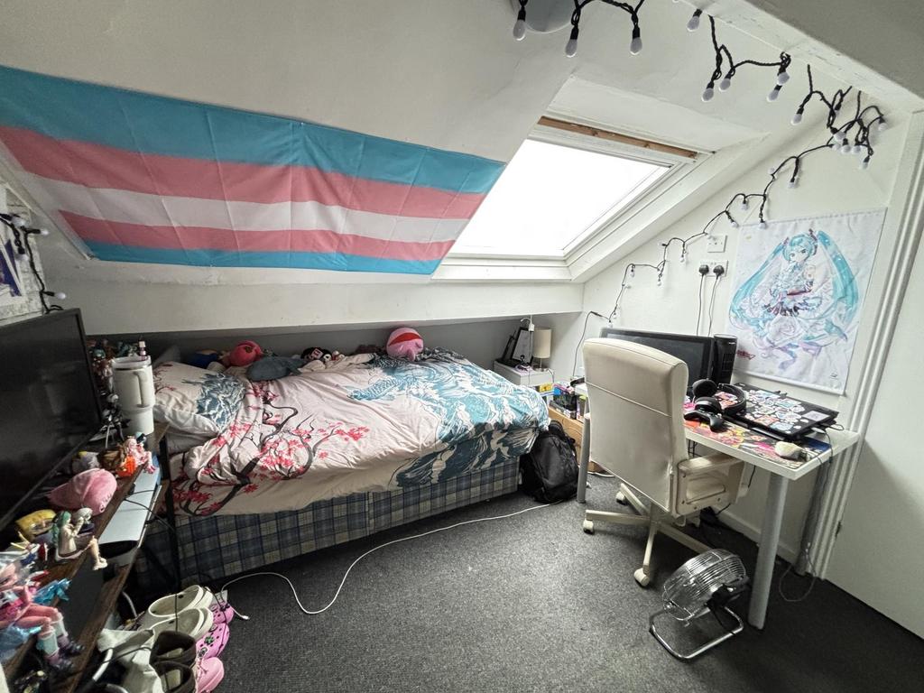 A cozy single bedroom with natural light from a...