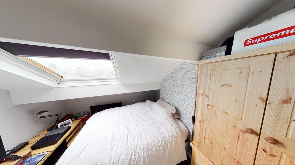 A cozy bedroom featuring a single bed with a pl...
