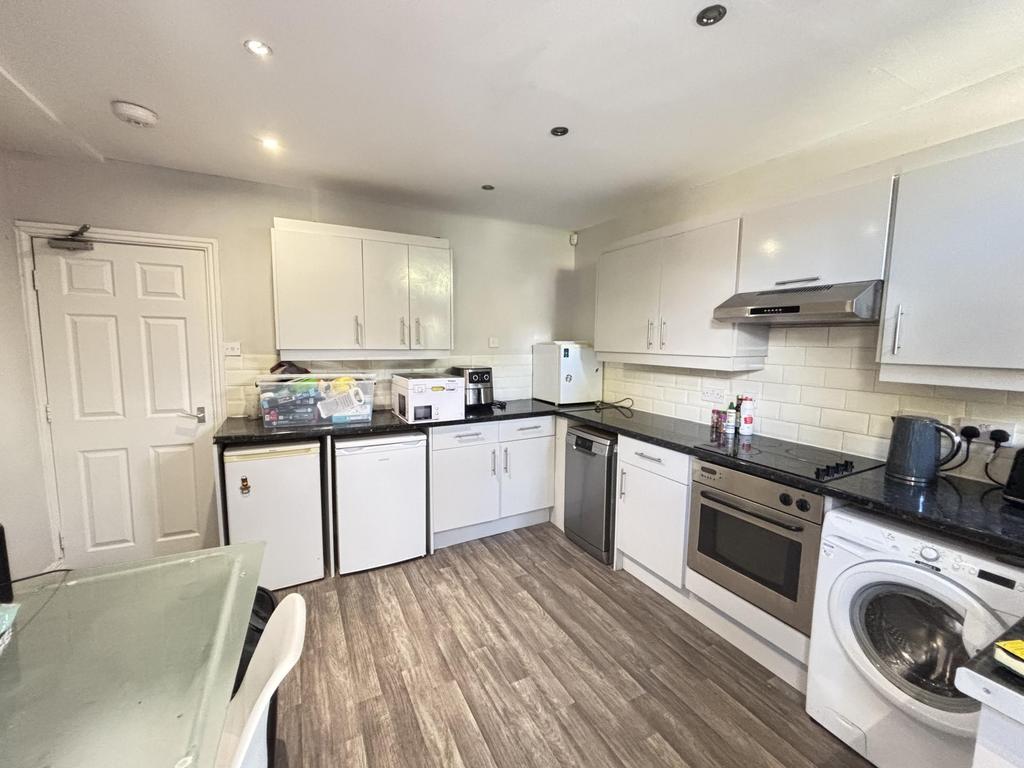 A modern, well-lit kitchen area featuring white...