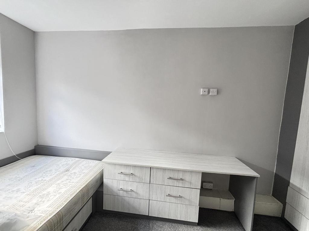 Bright, simply furnished bedroom with a built-i...