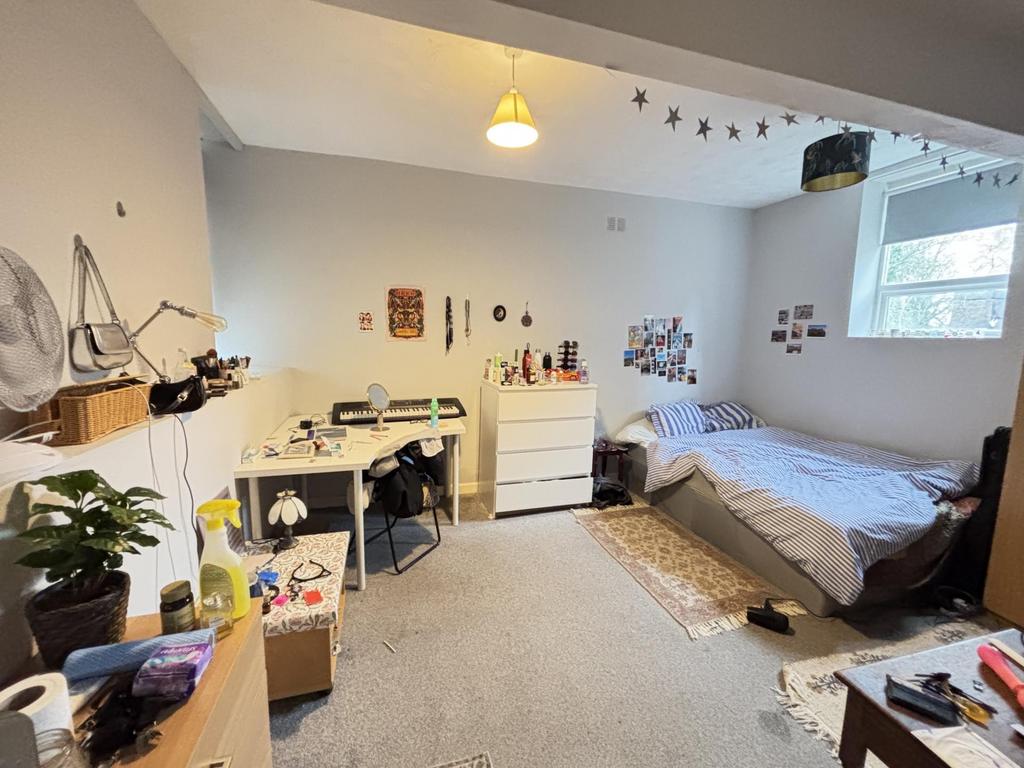 A well-lit, inviting bedroom featuring a comfor...